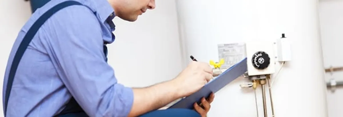 Water heater repair technician inspecting the unit and recording service notes in Glendale, AZ