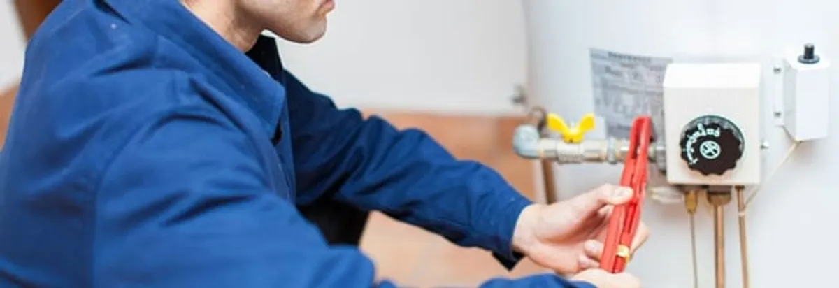 Water heater repair technician adjusting the temperature control and gas valve in Glendale, AZ